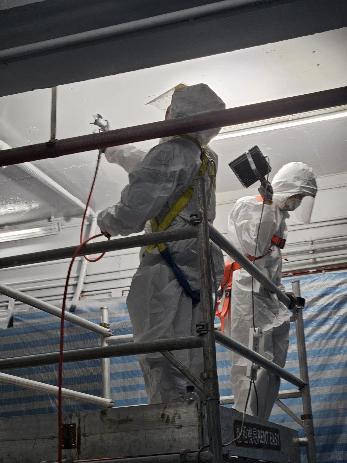 Worker applying RD-Aquasorb to the ceiling using an airless sprayer