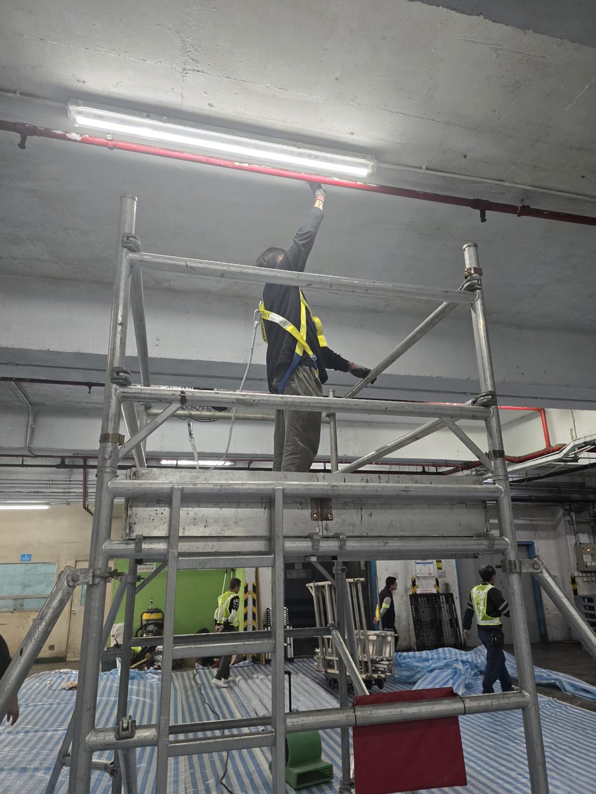 Worker applying RD-Aquasorb to the ceiling using an airless sprayer