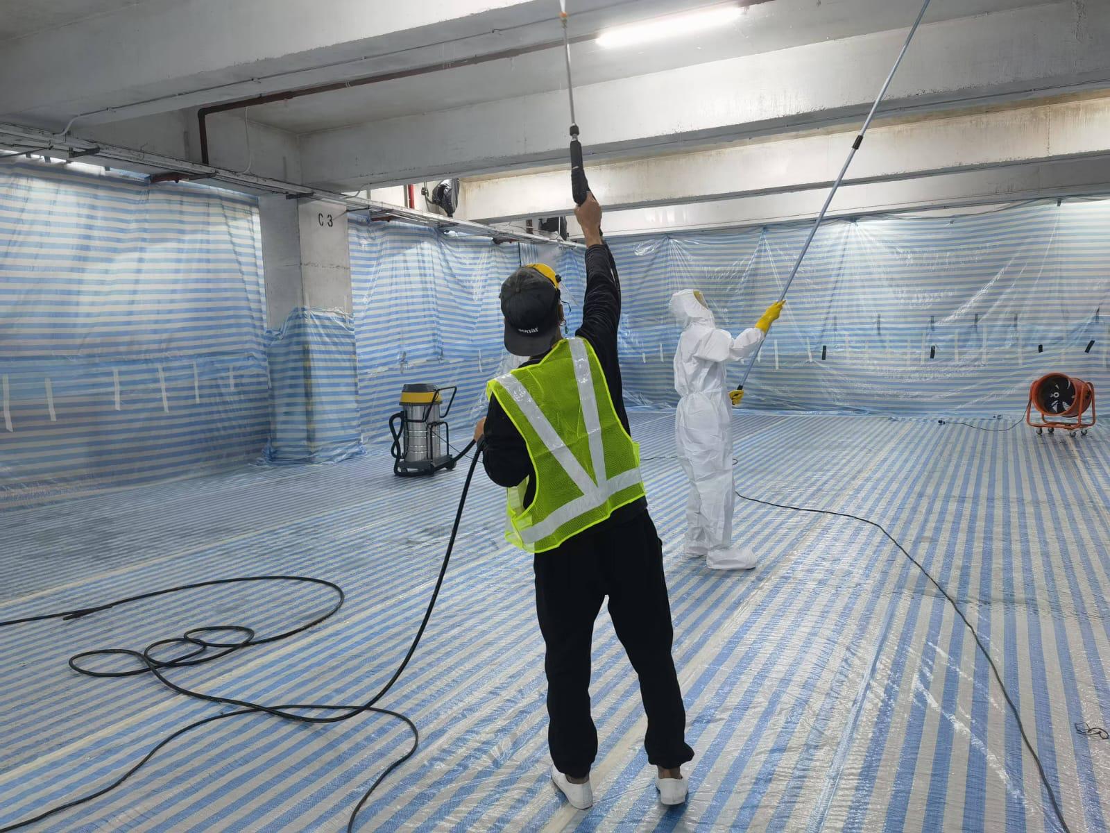 Worker applying RD-Aquasorb to the ceiling using an airless sprayer